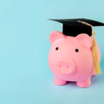 Pink piggy money bank with graduation cap