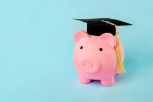 Pink piggy money bank with graduation cap